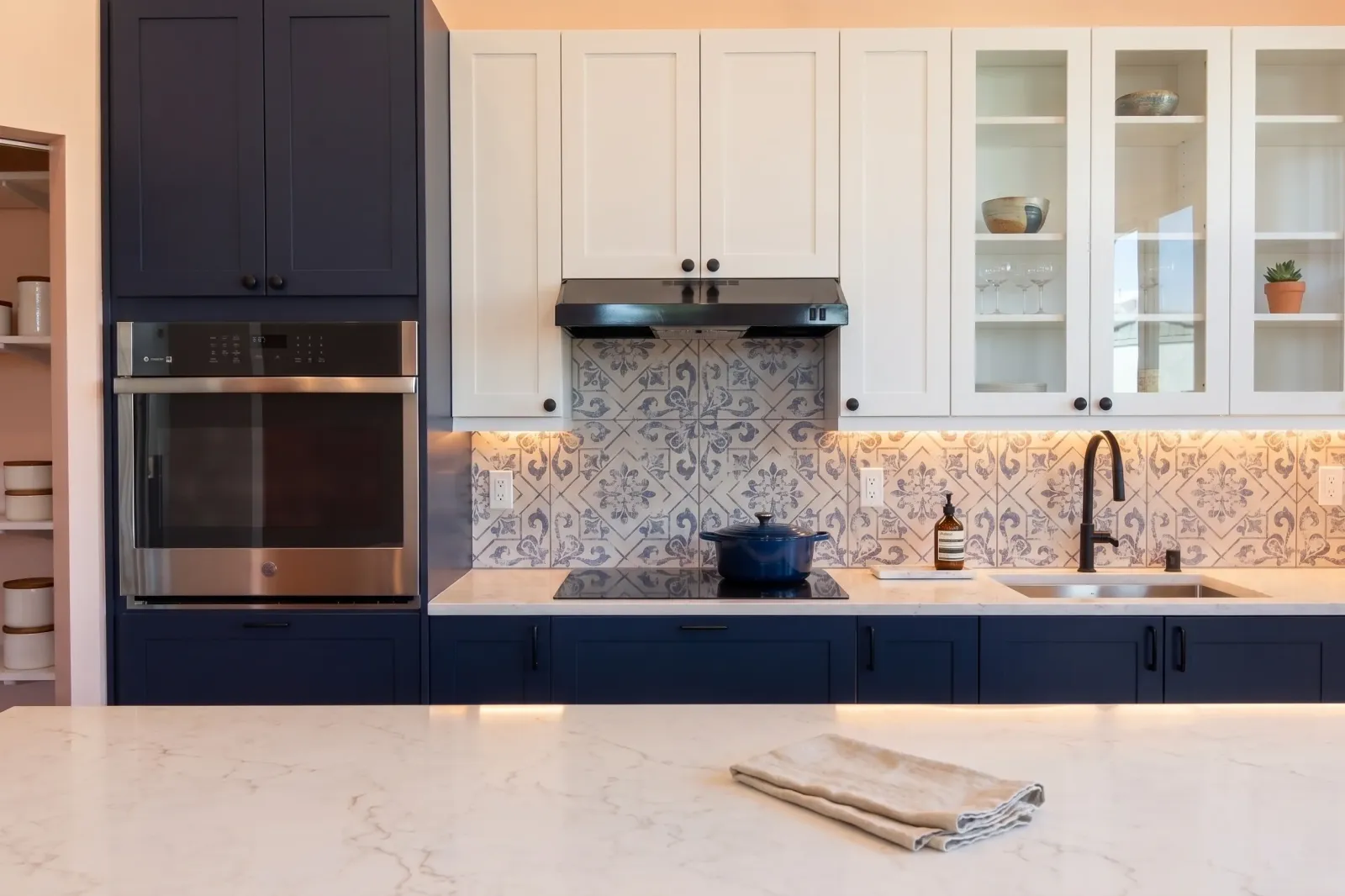 Blue kitchen with white upper cabinets