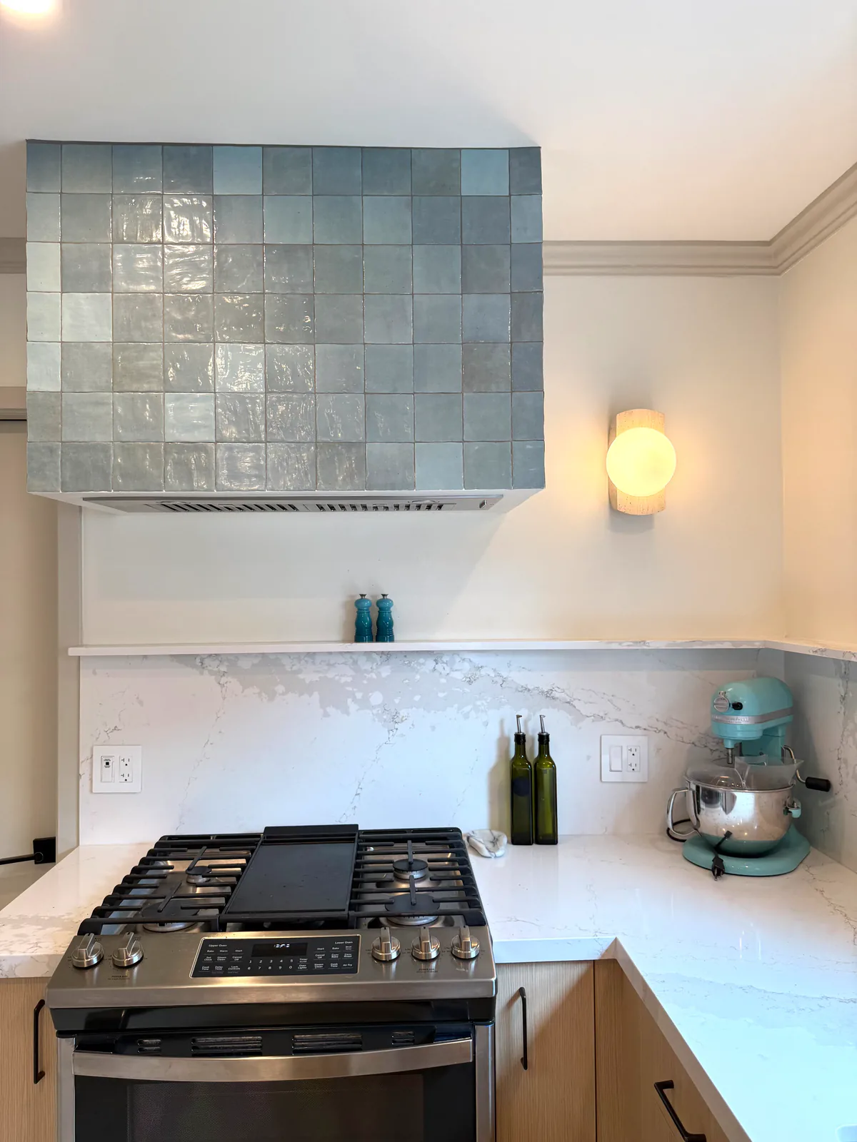 Detail of the blue zellige tile hood and travertine sconce