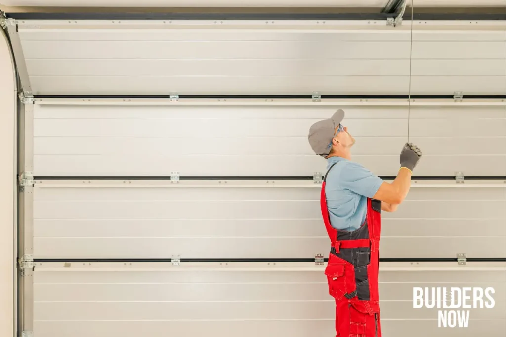 Worker inspecting a garage door for potential conversion to living space.